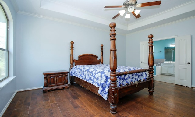 bedroom featuring ornamental molding, baseboards, a tray ceiling, and hardwood / wood-style flooring