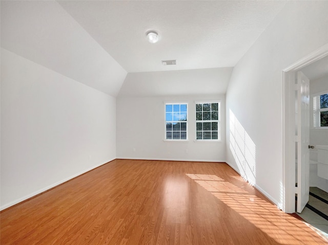 bonus room with visible vents, plenty of natural light, baseboards, and wood finished floors