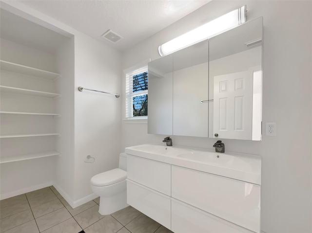 full bath featuring visible vents, baseboards, double vanity, tile patterned floors, and toilet