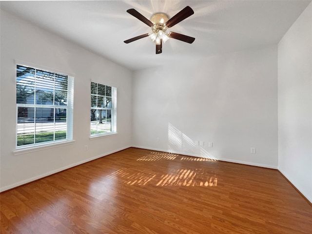 empty room featuring a ceiling fan, wood finished floors, and baseboards