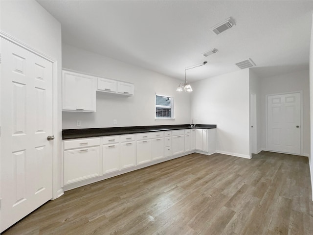 kitchen featuring visible vents, white cabinets, and light wood finished floors