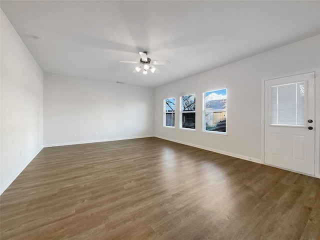 unfurnished living room with a ceiling fan, wood finished floors, and baseboards