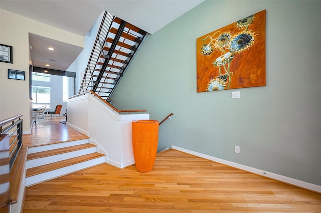 stairs featuring recessed lighting, wood finished floors, and baseboards