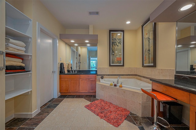 bathroom featuring visible vents, recessed lighting, vanity, and a garden tub