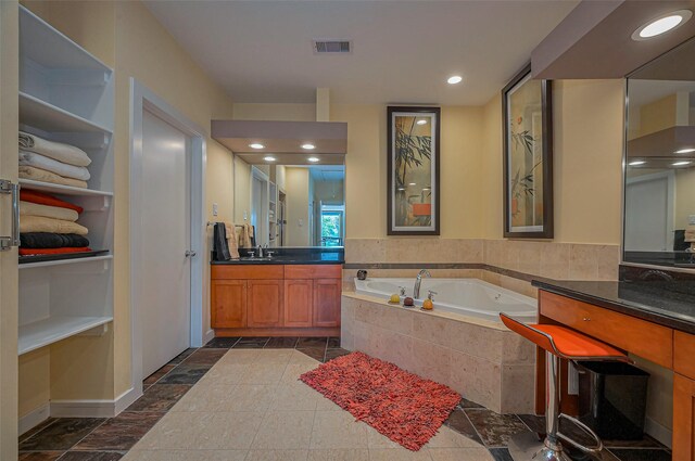 full bathroom featuring baseboards, visible vents, recessed lighting, a garden tub, and vanity