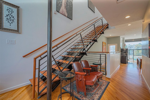 staircase with recessed lighting, baseboards, and wood finished floors