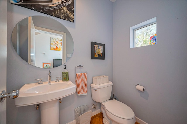 half bath featuring toilet and baseboards