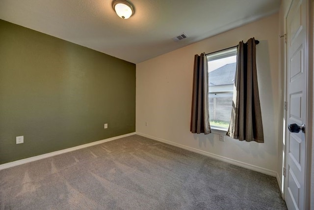 empty room featuring baseboards, visible vents, and carpet floors