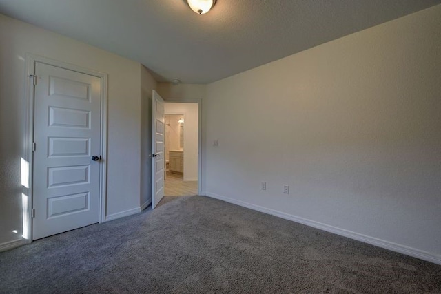 unfurnished bedroom featuring light colored carpet and baseboards