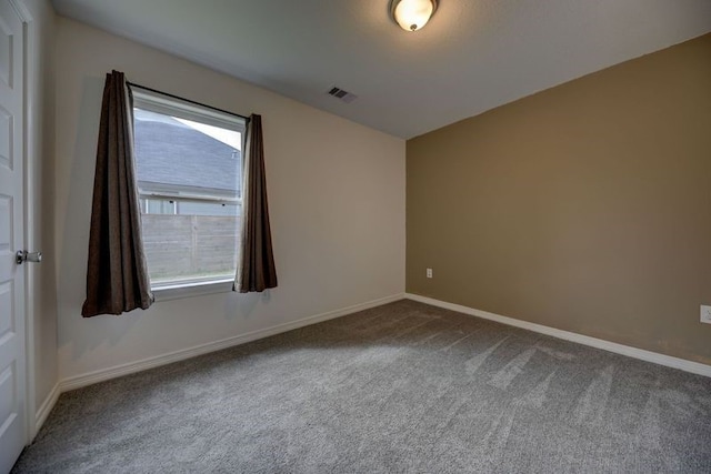 carpeted empty room featuring visible vents and baseboards
