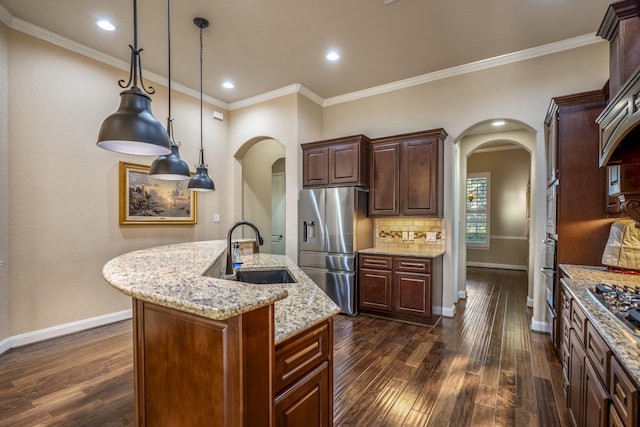 kitchen with arched walkways, dark wood finished floors, appliances with stainless steel finishes, and a sink