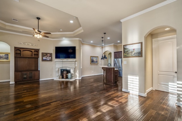 unfurnished living room featuring visible vents, a fireplace with raised hearth, arched walkways, baseboards, and dark wood-style flooring