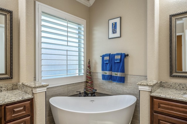 full bath featuring a wainscoted wall, vanity, tile walls, and a freestanding tub