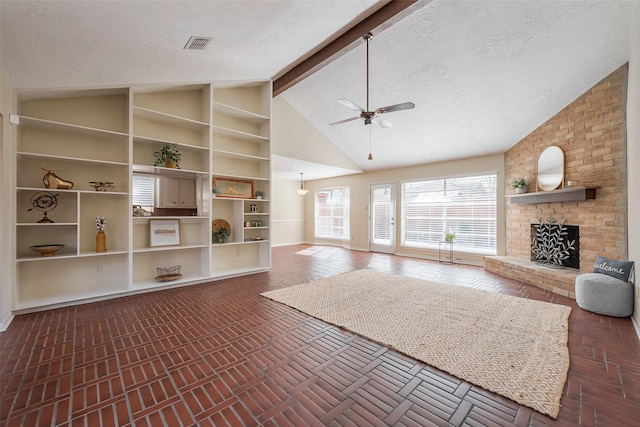 interior space featuring visible vents, beam ceiling, ceiling fan, a textured ceiling, and a brick fireplace