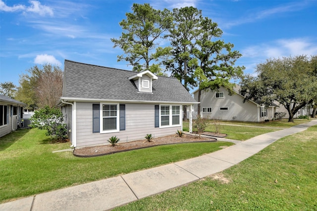 view of front of home with roof with shingles and a front yard