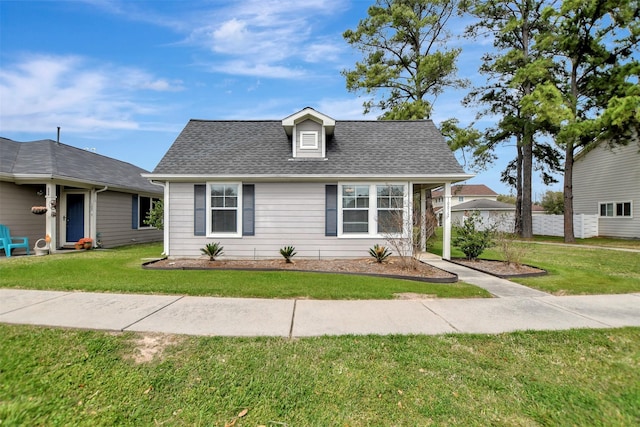 view of front of home featuring a front lawn and a shingled roof