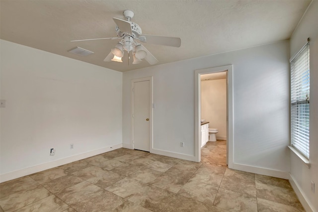 unfurnished bedroom with a ceiling fan, baseboards, visible vents, and ensuite bathroom