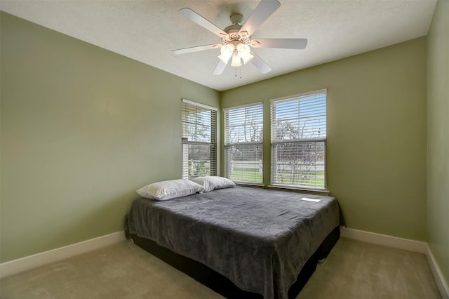 bedroom with baseboards, carpet, and a ceiling fan