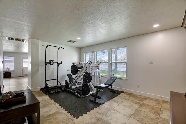 workout area featuring a healthy amount of sunlight, visible vents, and baseboards