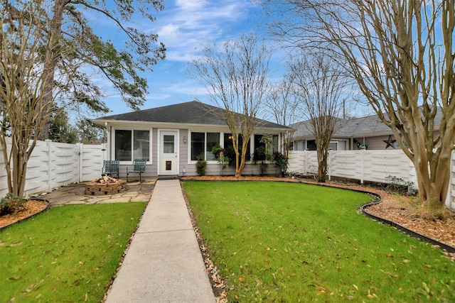 single story home featuring a front yard, a fenced backyard, and an outdoor fire pit