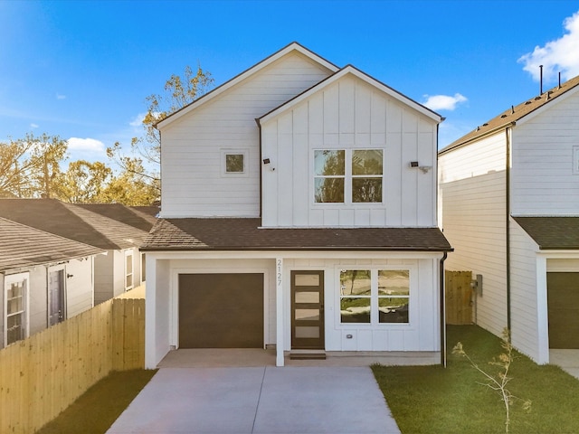 modern inspired farmhouse featuring board and batten siding, an attached garage, driveway, and fence