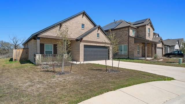 view of front facade with brick siding, solar panels, concrete driveway, and a front lawn