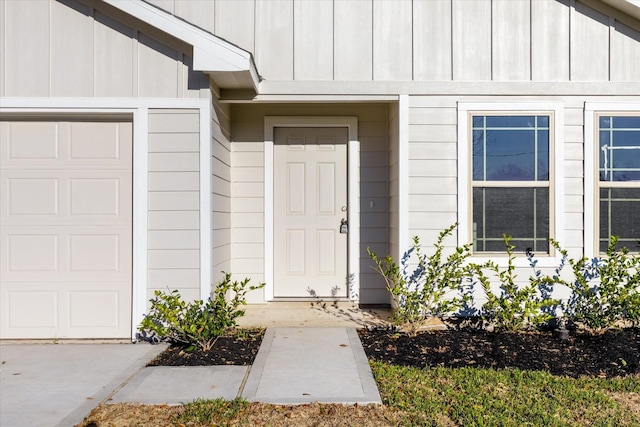 property entrance with board and batten siding and an attached garage