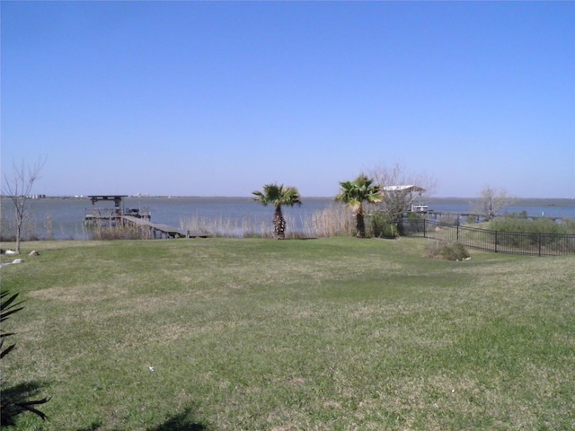 view of yard with a water view and fence