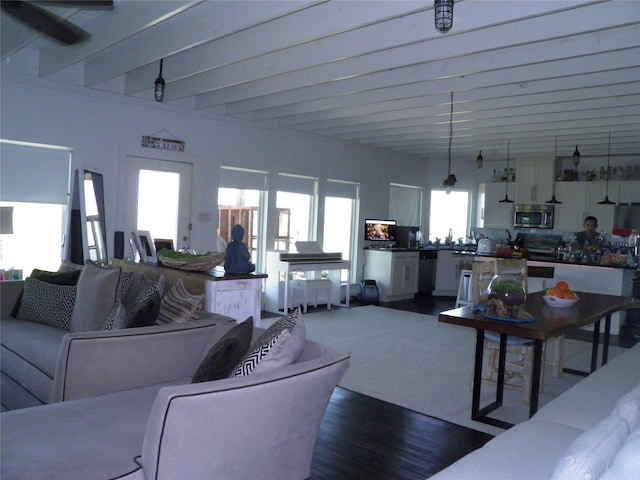 living room with beam ceiling and dark wood-type flooring