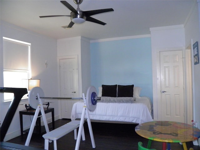 bedroom featuring ceiling fan, wood finished floors, and ornamental molding