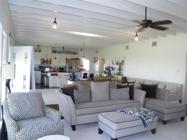 living room with beamed ceiling, visible vents, and ceiling fan