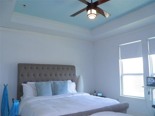 bedroom featuring a raised ceiling and ceiling fan