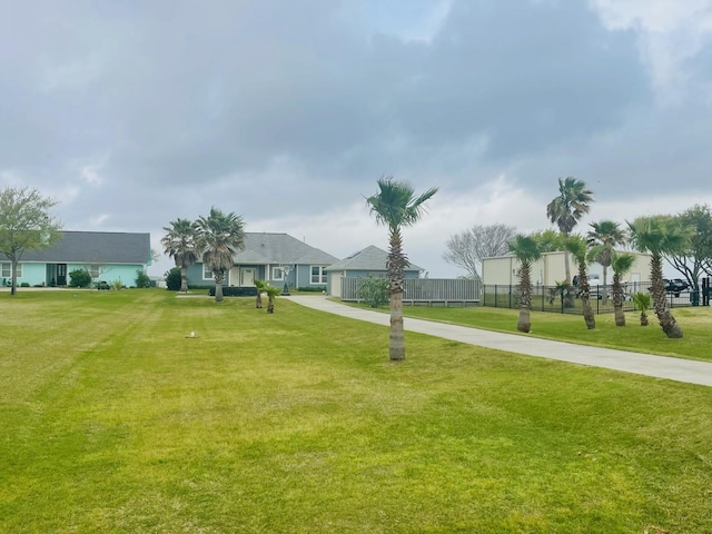 exterior space featuring a front lawn, driveway, and fence