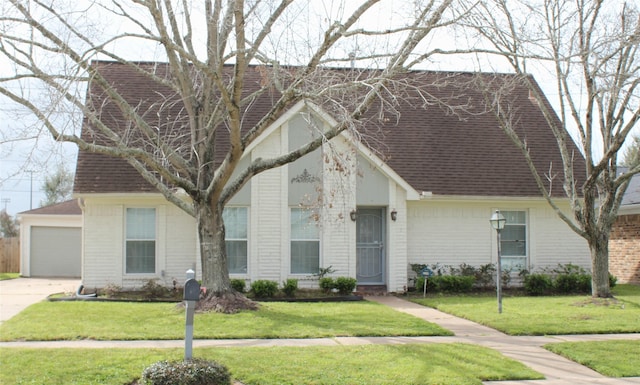 view of front of house with brick siding, a front yard, and a shingled roof