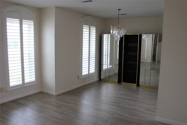1727 Eastfield Dr, Missouri City, TX 77459 - unfurnished dining area with a notable chandelier, baseboards, visible vents, and wood finished floors