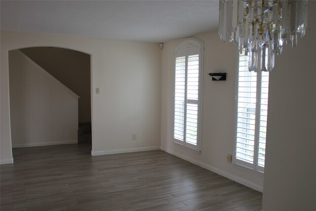 1727 Eastfield Dr, Missouri City, TX 77459 - unfurnished dining area with stairs, baseboards, arched walkways, and wood finished floors