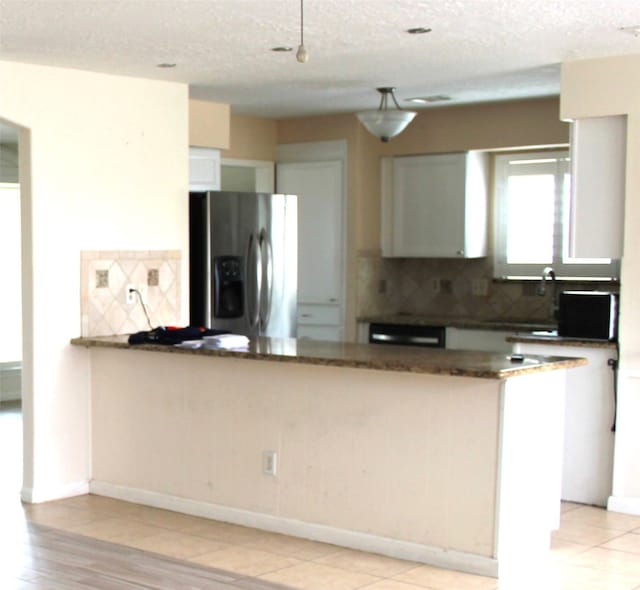 kitchen with tasteful backsplash, dishwashing machine, a peninsula, stainless steel fridge, and a sink