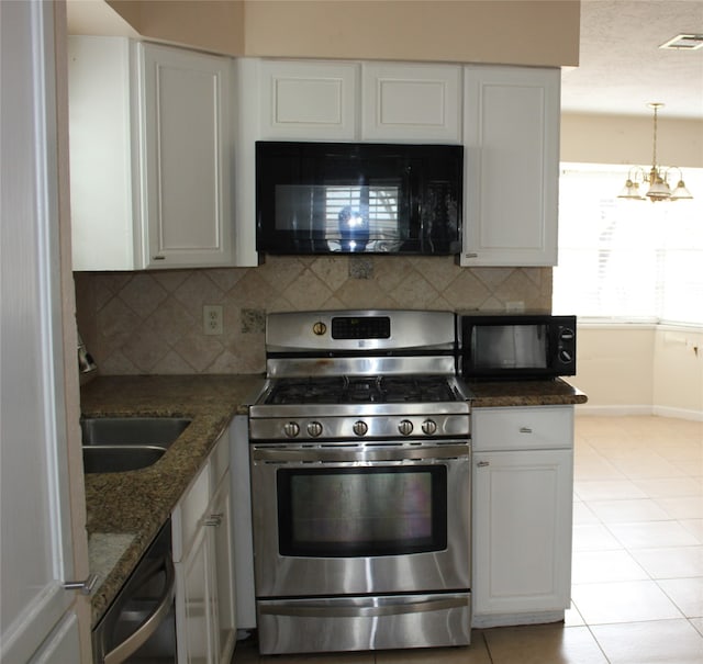 kitchen featuring stainless steel gas range, backsplash, visible vents, and black microwave