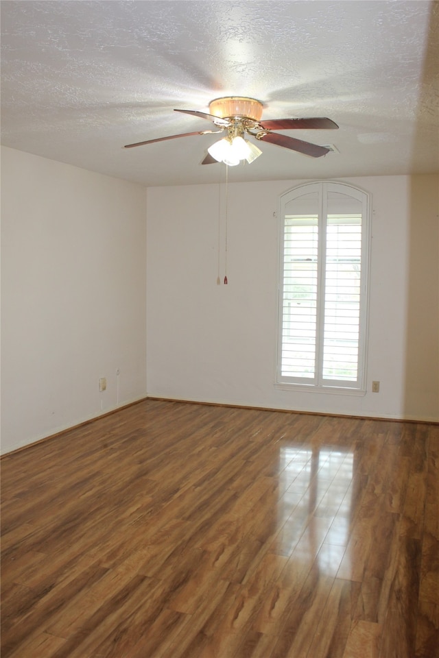 unfurnished room with ceiling fan, a textured ceiling, and wood finished floors