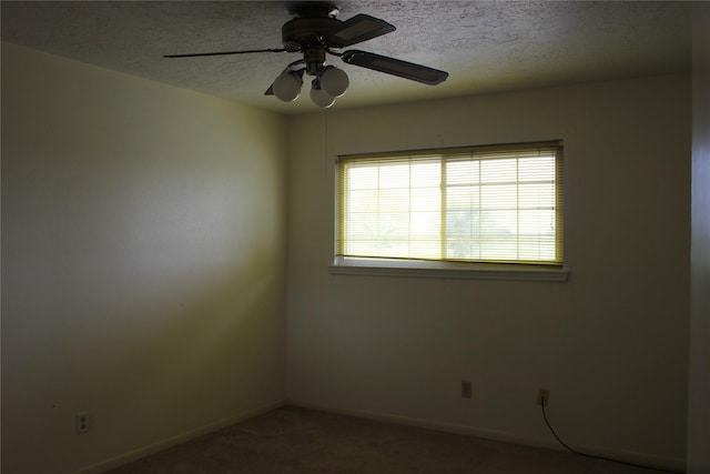 unfurnished room with baseboards, ceiling fan, a textured ceiling, and carpet