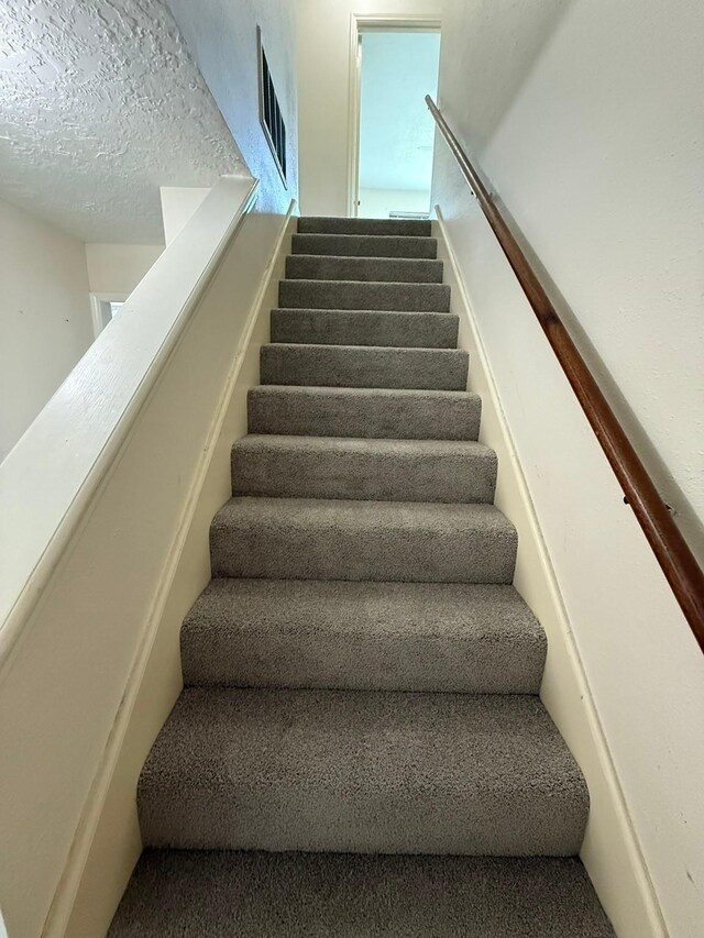 1727 Eastfield Dr, Missouri City, TX 77459 - stairs featuring a textured ceiling