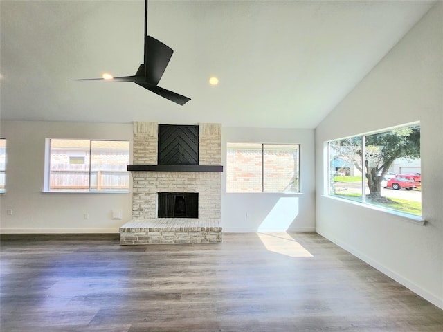 unfurnished living room featuring a ceiling fan, wood finished floors, baseboards, and a fireplace