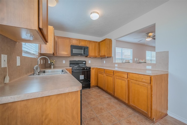 kitchen with light tile patterned floors, ceiling fan, a sink, black appliances, and light countertops