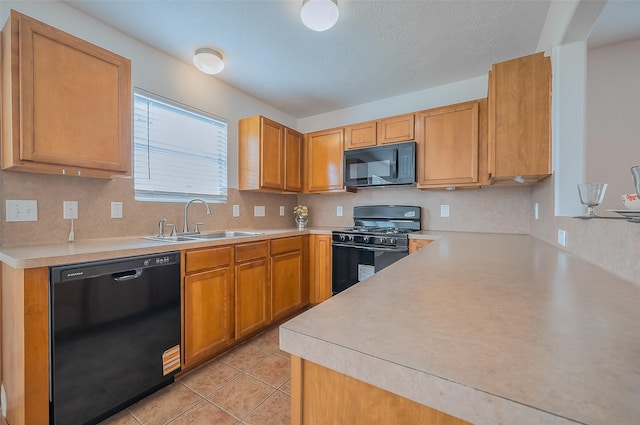 kitchen featuring light tile patterned flooring, a sink, black appliances, light countertops, and a textured ceiling