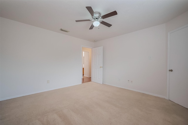 unfurnished room featuring baseboards, light colored carpet, visible vents, and ceiling fan