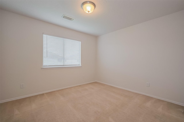 unfurnished room with visible vents and light carpet