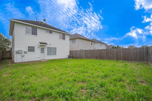 back of property featuring central air condition unit, a lawn, and a fenced backyard