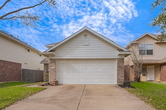 view of front of home with brick siding, an attached garage, driveway, and fence