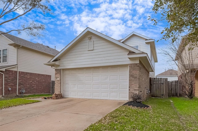 traditional-style home featuring a front lawn, fence, concrete driveway, an attached garage, and brick siding