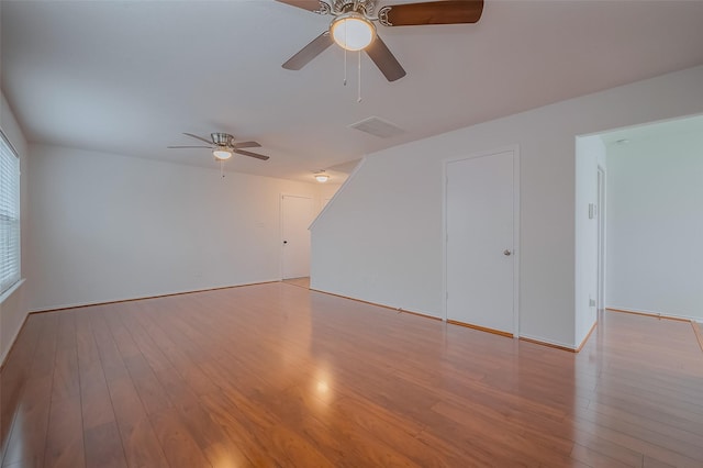 spare room featuring visible vents, ceiling fan, and wood finished floors